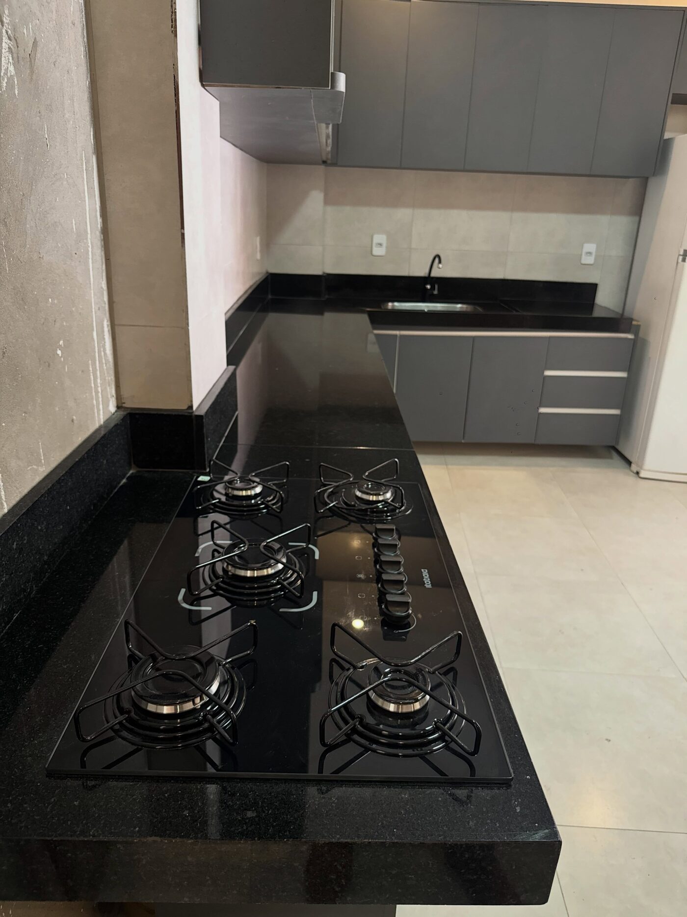 Cozinha com bancada e cooktop em granito preto